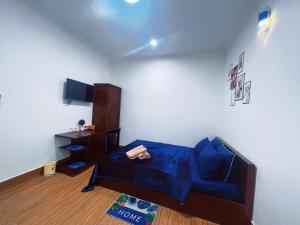 芹苴的住宿－Nhan Tay Hostel，客厅配有蓝色的床和橱柜。