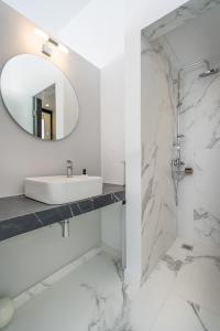 a white bathroom with a sink and a mirror at Olvar's Modern Luminous Suite , Athens Downtown in Athens
