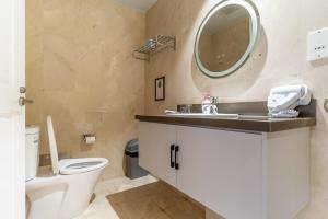 a bathroom with a toilet and a sink and a mirror at The Rixx Lancaster Apartment @ D1/ Netflix/bathtub in Ho Chi Minh City +12 photos