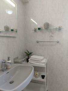 a white bathroom with a sink and a mirror at Casa em Palmela - Setúbal in Palmela