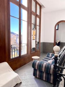 ein Wohnzimmer mit einem Sofa und einem großen Fenster in der Unterkunft Demeure des Dentelles in Le Puy en Velay