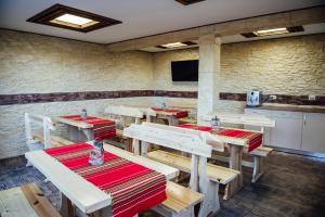 a restaurant with wooden tables and chairs in a room at Къща за гости Давиос in Sapareva Banya