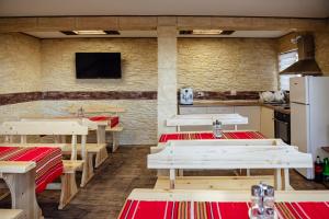 a restaurant with wooden tables and a tv on a wall at Къща за гости Давиос in Sapareva Banya