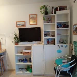 a living room with a tv on a white book shelf at Aguas Verdes in Betancuría +27 photos
