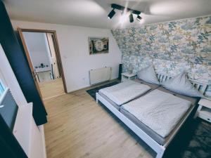 um quarto com uma cama e uma parede com flores em Ferienhaus Rasmussen em Tönning