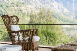 a wicker chair on a balcony with a view of a mountain at HHBCN Villa El Castell in El Bruc