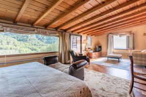 a bedroom with a bed and a large window at HHBCN Villa El Castell in El Bruc