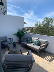 patio con sofá y mesas en el balcón en Casa do Ti-Zé, en Pêra