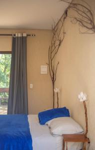 um quarto com uma cama com uma árvore na parede em La em casa Noronha em Fernando de Noronha