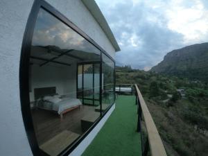 Schlafzimmer mit einem Bett auf einem Balkon mit Aussicht in der Unterkunft Glamping Villa Transito in Machetá