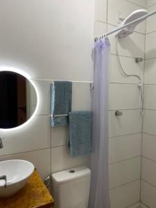 uma casa de banho com um WC, um lavatório e um espelho. em La em casa Noronha em Fernando de Noronha
