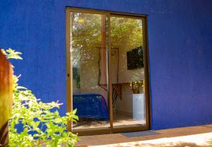 uma parede azul com uma porta de vidro à frente em La em casa Noronha em Fernando de Noronha