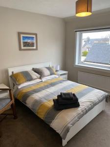 a bedroom with a bed with a black bag on it at 7 BR for 10 people in town in Stornoway