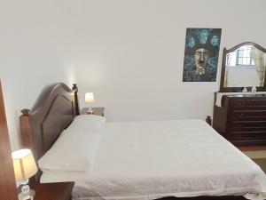 - une chambre avec un lit, une commode et un miroir dans l'établissement Casa em Palmela - Setúbal, à Palmela
