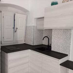 uma cozinha com armários brancos e um lavatório em Casa Isabella De Luxe Studio em Monterosso al Mare