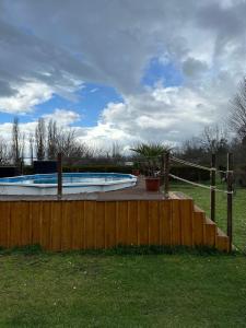 a swimming pool in a yard with a wooden fence at La Bonbonniere in Saint Agne