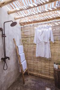a white shirt hanging on a rack in a bathroom at Bamboo Zanzibar in Jambiani