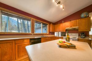 eine Küche mit Holzschränken und einem Tisch mit einer Flasche Wein in der Unterkunft Fairmont Hot Springs, 3 Bedroom Vacation Home in Fairmont Hot Springs + 9 Fotos