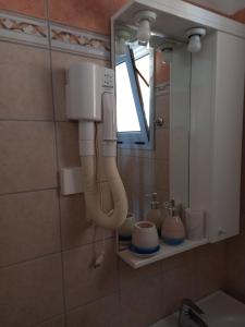 a bathroom with a blow dryer on the wall at Lidovois House in Pelekas