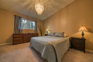 a bedroom with a bed and a window and a chandelier at Fairmont Hot Springs, 3 Bedroom Vacation Home in Fairmont Hot Springs