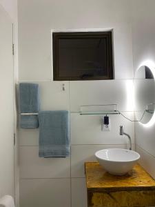La salle de bains est pourvue d'un lavabo, d'une télévision et de serviettes. dans l'établissement La em casa Noronha, à Fernando de Noronha