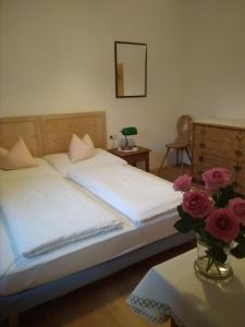 "Michls Hoamat" Ötztal Summer Card inklusive في سولدن: غرفة نوم بسريرين و مزهرية ورد على طاولة