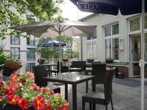 a table and chairs with an umbrella on a patio at Hotel Villa Elsa in Bad Kissingen