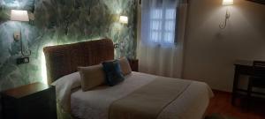 a bedroom with a bed with two pillows on it at La Casona de Revolgo in Santillana del Mar