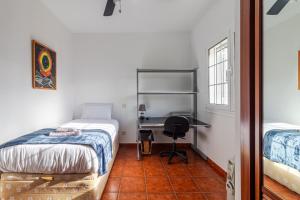 a bedroom with two beds and a desk in it at Flatguest Villa Mayca in Santa Brígida