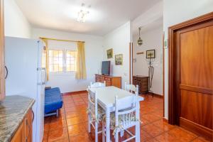a kitchen and dining room with a white table and chairs at Flatguest Villa Mayca in Santa Brígida