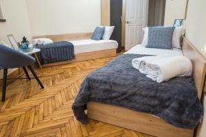 een slaapkamer met 2 bedden en een houten vloer bij Apartment Zdravets in Veliko Tŭrnovo