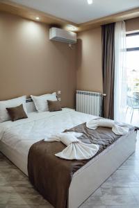 sypialnia z dużym łóżkiem z białą pościelą w obiekcie Къща за гости Давиос w mieście Saparewa Banja