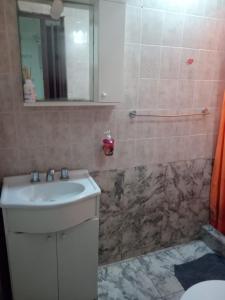 ein Bad mit einem Waschbecken und einem Spiegel in der Unterkunft LOURDES in Yerba Buena