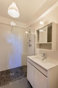 uma casa de banho branca com um lavatório e um chuveiro em Branco em Sagres