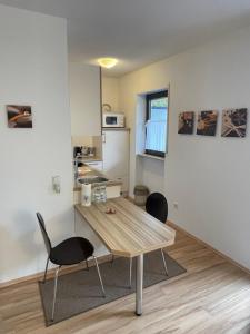 eine Küche mit einem Holztisch und 2 Stühlen in der Unterkunft Ferienwohnung David im Haus Waldblick - Bad Bergzabern in Bad Bergzabern