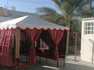 a circus tent with a red and white canopy at Haret Nizwa hostel in Nizwa