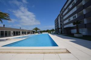 a large swimming pool next to a building at Essence 516 em Atlântida in Xangri-lá