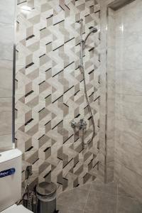 um chuveiro na casa de banho com uma parede em azulejo em Къща за гости Давиос em Sapareva Banya