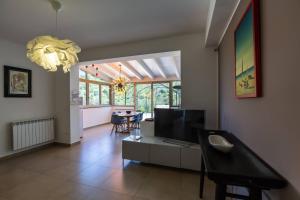 a living room with a television and a dining room at Residence Mersa in Brolo