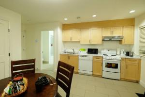 a kitchen with a table and a stove top oven at Beautiful 1 Bedroom Garden Suite in Metrotown in Burnaby