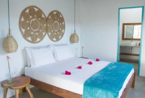 ポルト・デ・ペードラスにあるCHALÉ NAMORADA PATACHOのベッドルーム1室(赤い花の白いベッド1台付)