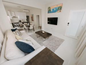 Una sala de estar con un sofá blanco y una mesa. en Luxurious Beachside 3-Br Apt, en San Juan