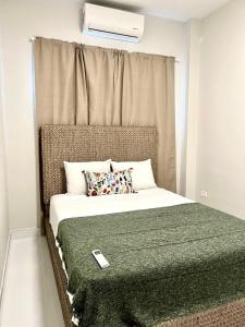 Un dormitorio con una cama con una manta verde. en Luxurious Beachside 3-Br Apt, en San Juan