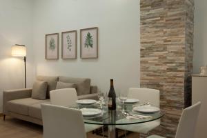 a dining room with a glass table and a couch at ADDA Loft La Oficina in Alicante