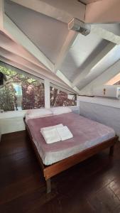 uma cama grande num quarto com uma janela em Linda Casa Praia de Pauba em condominio em São Sebastião