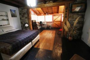 1 dormitorio con 1 cama en una cabaña de madera en Casa de Montaña en San Carlos de Bariloche