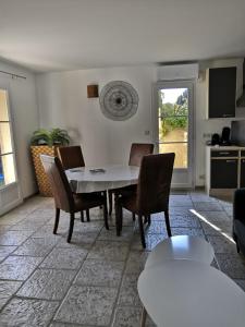 een woonkamer met een witte tafel en stoelen bij LA BASTIDE DES MACALO in Pont-Saint-Esprit