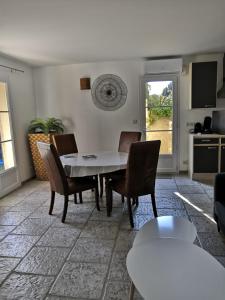 salon z białym stołem i krzesłami w obiekcie LA BASTIDE DES MACALO w mieście Pont-Saint-Esprit