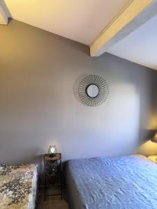 een slaapkamer met 2 bedden en een spiegel aan de muur bij LA BASTIDE DES MACALO in Pont-Saint-Esprit