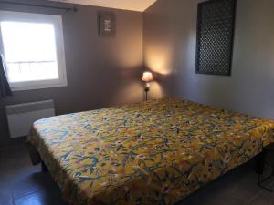 een slaapkamer met een bed met een kleurrijke sprei bij LA BASTIDE DES MACALO in Pont-Saint-Esprit